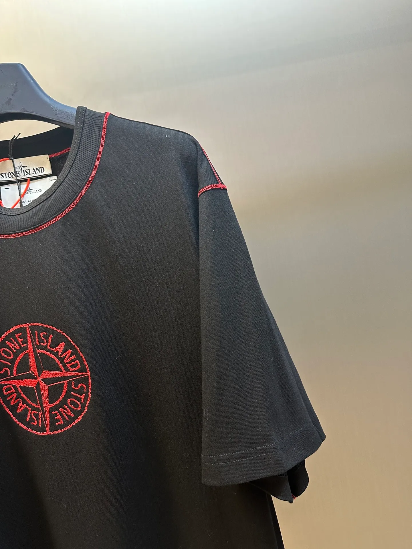🅿️270 Stonelsland Badge Embroidered Short Sleeves Customized elegant black silk cotton and linen plain fabric, with iconic red Compass badge embroidery on the chest, stitching art, and the beauty of contrasting colors. The red stitches jump on the black base. The collision of fashion and creativity exudes irresistible charm. Imported machine embroidery technology is used, and advanced computer control systems and precision mechanical components are used to realize the red Compass badge embroidery operation. Special machine for reverse topstitching and fine sewing process. Special machine is used for topstitch sewing. It requires careful preparation of the reverse side of the garment before sewing to ensure that the sewing lines are straight, the stitches are even, and the edges are smooth and beautiful.  size：s m l xl